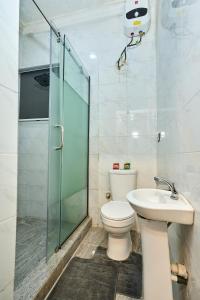 a bathroom with a toilet and a shower and a sink at Shabi's Court in Lagos
