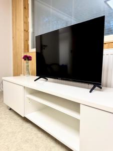 a white entertainment center with a large television on it at Arctic Elf Apartment in Rovaniemi