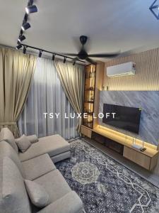 a living room with a couch and a tv at TSYLuxeLoft 4BR Near UKM & Bangi Toll in Bandar Baru Bangi