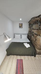 a bedroom with a bed with a stone wall at Casa do Apeadeiro in Vila Pouca de Aguiar