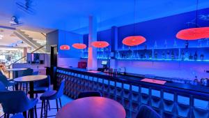 a bar with blue walls and tables and chairs at Base Backpackers in Ho Chi Minh City