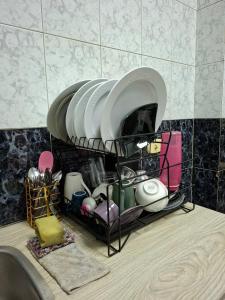 a drying rack with plates and dishes on a sink at Cairo Backpacker Central Hostel in Cairo