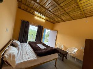 a bedroom with a bed and a window at Datta's Heritage in Chaubattia