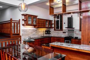 a kitchen with wooden cabinets and granite counter tops at Charleston Homestay in Gampola