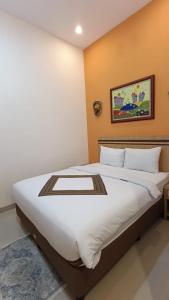 a bedroom with a large white bed in a room at The Cabin Hotel Sidoarum in Sleman +3 photos