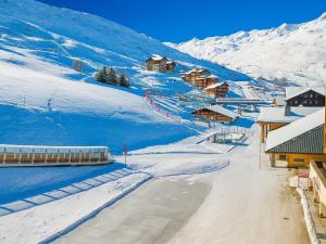 a snow covered mountain with houses and a road at Studio cabine 4 pers, balcon, animaux autorisés - FR-1-452-279 in Les Menuires