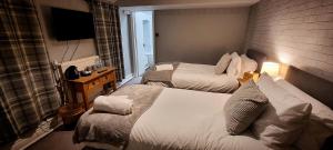 una camera d'albergo con due letti e una televisione di The Royal Oak, Settle a Settle