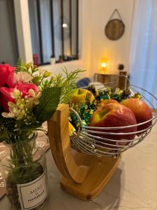 a bowl of apples and flowers on a table at Appartement-Terrasse in Montbéliard
