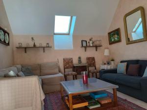 a living room with a couch and a table at Charmant gîte en Normandie avec jardin et activités à sensations - FR-1-410-300 in Arçonnay