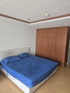 a bedroom with a blue bed and a wooden cabinet at Studio apartment in Trendy Bankok in Bangkok