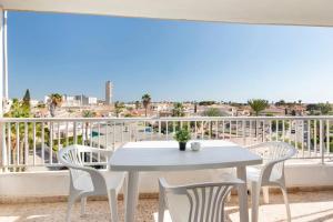a table and chairs on a balcony with a view of the city at Bahía Mar Apartamento in Puerto de Mazarrón