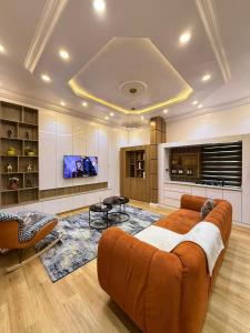 a large living room with a couch and a tv at Comfy 1 bed in Lekki +6 photos