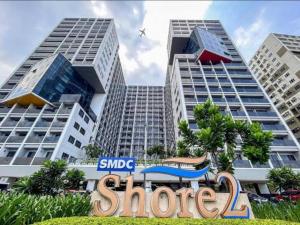 a sign in front of two tall buildings at Shore 2 tower 2 in Manila