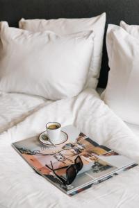 a tray with a cup of coffee and glasses on a bed at The Social Hub Maastricht in Maastricht