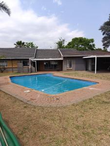 ein Swimmingpool vor einem Haus in der Unterkunft TRIANGLE STARS Guest House in Kempton Park