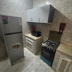 a small kitchen with a stove and a refrigerator at Ruslan in Muscat