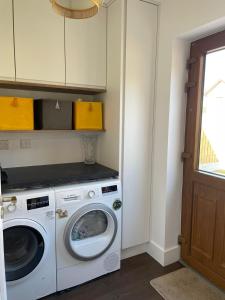 a laundry room with a washer and dryer at EV friendly & Stylish Dunmore East Holiday Home Sleeps 7 in Dunmore East