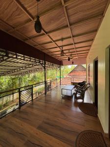 a large room with a wooden floor and a balcony at The Munroe Vibes Inn in Munroe Island