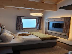 a bedroom with a bed and a window and a television at Apartment in Kaltenbach near Ski Lift in Kaltenbach +23 photos