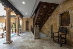 a hallway with columns and a staircase in a house at Hotel Boutique Casón De Los López in Toledo
