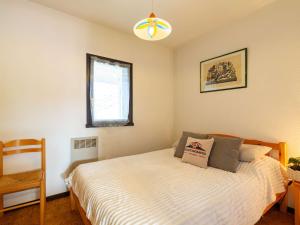 a bedroom with a bed and a chair and a window at Appartement T2 sud, calme, proche Saint-Lary, 4 pers. - FR-1-296-523 in Bourisp