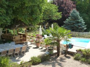 a backyard with a pool and chairs and a tree at Chambre Eglantine: Charme en Val de Loire avec Piscine et Wifi - FR-1-590-515 in Tavers