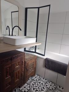 ein Badezimmer mit Waschbecken und Spiegel in der Unterkunft Boheme chic aux portes de Paris in Deuil-la-Barre