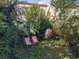 zwei Stühle im Hof eines Hauses in der Unterkunft Boheme chic aux portes de Paris in Deuil-la-Barre
