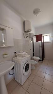 a bathroom with a washing machine and a toilet at Appartamento, Le Castella ,Residence San Francisco in Le Castella