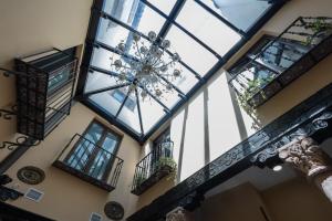 an image of a building with windows and a chandelier at Hotel Boutique Casón De Los López in Toledo