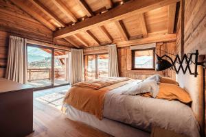 a bedroom with a bed in a room with wooden walls at Belmont - New & ecological chalet in the heart of Combloux in Combloux