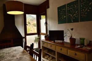 a bedroom with a desk with a television on it at Casa rural Hitohouse Bed&Climb in Albarracín