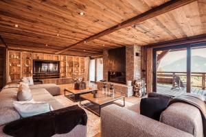 a living room with two couches and a fireplace at Belmont - New & ecological chalet in the heart of Combloux in Combloux