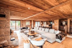 a living room with couches and a stone wall at Belmont - New & ecological chalet in the heart of Combloux in Combloux