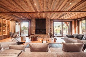 a living room filled with furniture and a fireplace at Belmont - New & ecological chalet in the heart of Combloux in Combloux