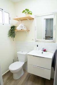 a white bathroom with a toilet and a sink at Piso Acogedor a Metros de la Plaza de las Flores in Murcia