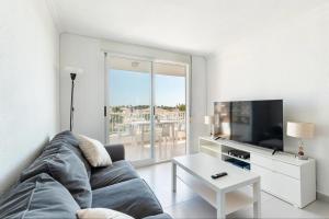 a living room with a couch and a tv at Bahía Mar Apartamento in Puerto de Mazarrón