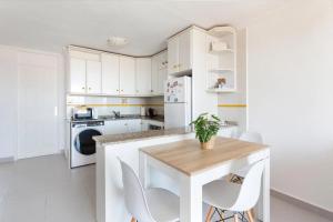 a kitchen with white cabinets and a table and chairs at Bahía Mar Apartamento in Puerto de Mazarrón