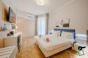 a hotel room with two beds and a flat screen tv at Hotiday Santa Margherita Porto in Santa Margherita Ligure