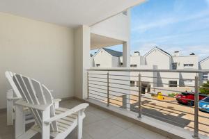 Un balcón con una silla blanca y vista a un coche. en Bona View Estate 30, en Cape Town 17 fotos más
