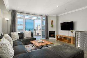 Una sala de estar con un sofá y un televisor. en Bona View Estate 30, en Cape Town