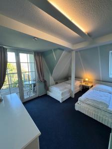 a bedroom with two beds and a balcony at Ferienwohnung im Poolhaus mit Ostseeblick in Wittenbeck