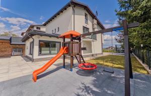 un parque infantil con un tobogán naranja frente a una casa en Villa Tia by Villas Guide, en Karlovac