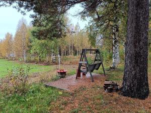 a swing set next to a tree in a field at Chalet Pellonranta 1 in Pello +10 photos