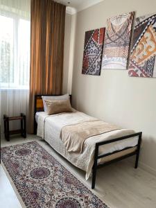 a small bedroom with a bed and a rug at Ala-Tor in Pokrovka
