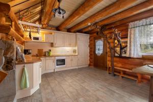 a kitchen with white cabinets and a wooden ceiling at Märchenhafte Ferienhäuser in Zaulsdorf