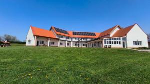 a large building with a green field in front of it at Halzóna in Balatonszabadi