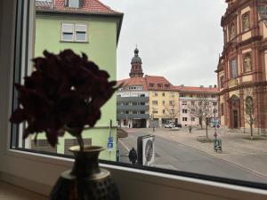 a vase in a window with a view of a city at MAIN Cozy Casa Peterplatz in Würzburg