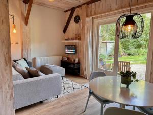 ein Wohnzimmer mit einem Tisch und einem Sofa in der Unterkunft B&B Woudzicht in Oudeschoot