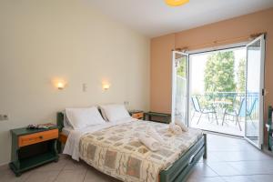 a bedroom with a bed and a balcony at Milos Studios in Lourdhata +58 photos